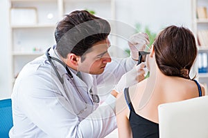 The doctor checking patients ear during medical examination photo