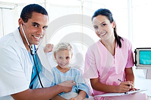 A doctor checking the pulse on a little girl