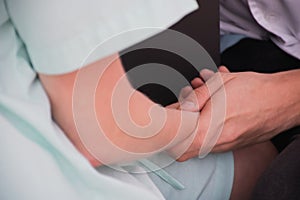 A doctor is checking the pulse on the patient hand