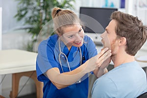 doctor checking throat on young male patient