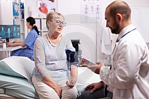 Doctor checking woman tension pressure using portable arm digital