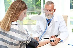 Doctor checking young woman`s pulse