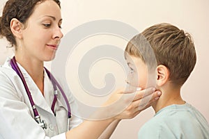 Doctor checks little boy lymph nodes