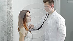 The doctor checks the patient's heartbeat with a stethoscope in the hospital.