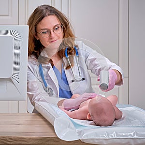 Doctor checks the temperature of the newborn baby with a thermometer. A nurse in uniform measures the child fever with a