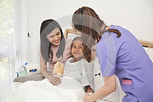 Doctor and child with mother in hospital
