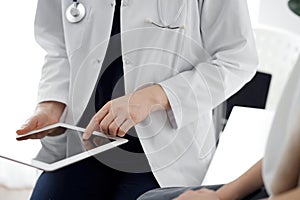 Doctor and child patient. The doctor is using tablet computer and is ready to examine the boy. The concept of ideal
