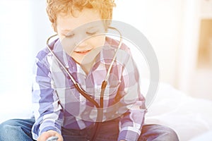 Doctor and child patient. Little boy play with stethoscope while physician communicate with him. hildren`s therapy and