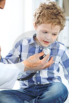 Doctor and child patient. Physician examines little boy by stethoscope. Medicine and children`s therapy concept