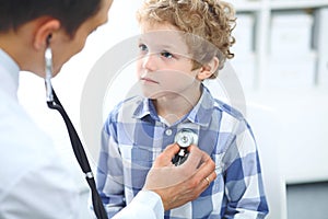 Doctor and child patient. Physician examines little boy by stethoscope. Medicine and children`s therapy concept