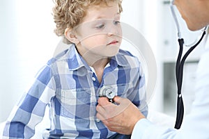 Doctor and child patient. Physician examines little boy by stethoscope. Medicine and children`s therapy concept