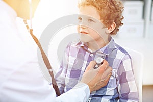 Doctor and child patient. Physician examines little boy by stethoscope. Medicine and children`s therapy concept