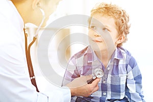 Doctor and child patient. Physician examines little boy by stethoscope. Medicine and children`s therapy concept