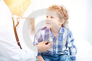 Doctor and child patient. Physician examines little boy by stethoscope. Medicine and children`s therapy concept