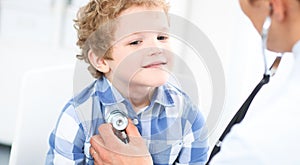 Doctor and child patient. Physician examines little boy by stethoscope. Medicine and children`s therapy concept