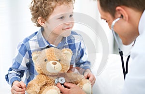 Doctor and child patient. Physician examines little boy by stethoscope. Medicine and children`s therapy concept photo