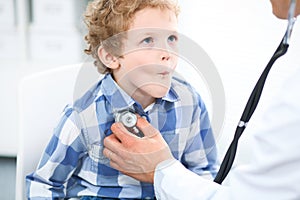 Doctor and child patient. Physician examines little boy by stethoscope. Medicine and children`s therapy concept