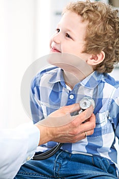 Doctor and child patient. Physician examines little boy by stethoscope. Medicine and children`s therapy concept