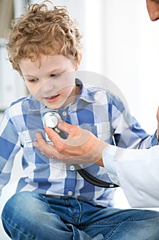 Doctor and child patient. Physician examines little boy by stethoscope. Medicine and children`s therapy concept