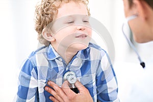 Doctor and child patient. Physician examines little boy by stethoscope. Medicine and children`s therapy concept