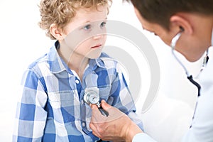 Doctor and child patient. Physician examines little boy by stethoscope. Medicine and children`s therapy concept