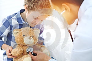 Doctor and child patient. Physician examines little boy by stethoscope. Medicine and children`s therapy concept