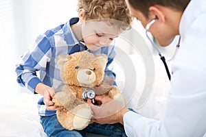 Doctor and child patient. Physician examines little boy by stethoscope. Medicine and children`s therapy concept