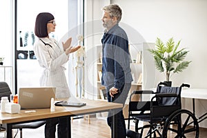 Doctor clapping while male standing on feet after accident