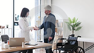 Doctor clapping while male standing on feet after accident