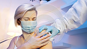 doctor clearing the arm of the woman with cotton gauze. Vaccination against covid19