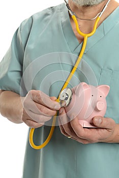 Doctor close up with stethoscope and piggy bank