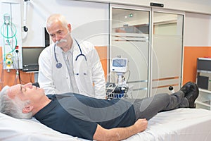 Doctor with clothed patient on hospital bed