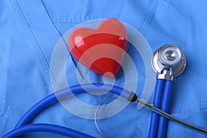 Doctor coat with medical stethoscope and red heart on the desk