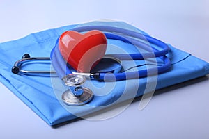 Doctor coat with medical stethoscope and red heart on the desk