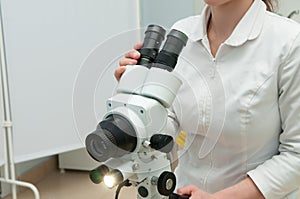 Doctor with colposcope in gynecology room