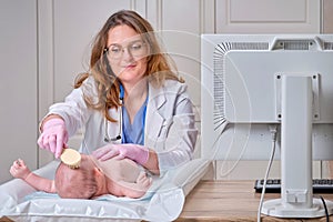 The doctor is combing the hair of a newborn baby. Nurse in uniform with a comb in hand for a child