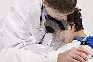 Doctor comforting little boy patient