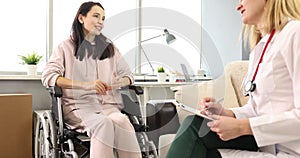 Doctor communicating with woman patient in wheelchair in rehabilitation center 4k movie slow motion