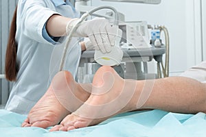 Doctor conducting ultrasound examination of patient`s foot