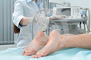 Doctor conducting ultrasound examination of patient`s foot