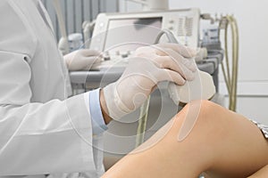 Doctor conducting ultrasound examination of patient`s knee