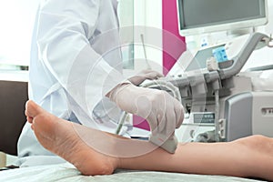 Doctor conducting ultrasound examination of patient`s leg in clinic