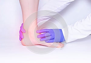 The doctor conducts a medical examination of the patient`s ankle joint to detect arthritis and synovitis, trauma, luxation photo