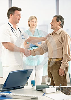 Doctor congratulating senior patient on recovery