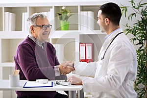 Doctor congratulating senior patient on recovery