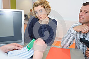 Doctor consoling worried couple on desk