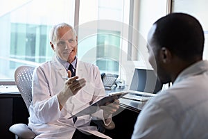 Doctor In Consultation With Male Patient In Office