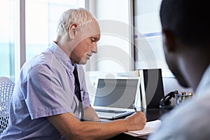 Doctor In Consultation With Male Patient In Office