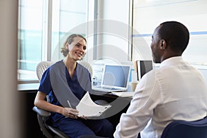 Doctor In Consultation With Male Patient In Office