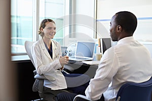 Doctor In Consultation With Male Patient In Office